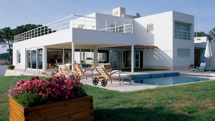 View of an eclectic house with a pool in front of it. (Photo by Quick Image/Construction Photography/Avalon/Getty Images)