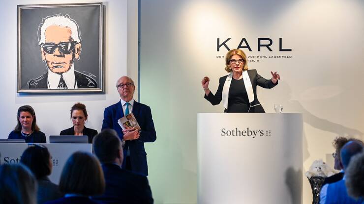 Auktionatorin gestikuliert während einer Lagerfeld-Auktion