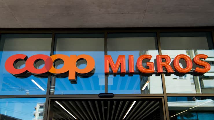 Le logo de la Coop et le logo de la Migros sont  photographies cote a cote sur un batiment commercial commun ce mardi 23 aout 2016 sur la place de la Sallaz a Lausanne. (KEYSTONE/Jean-Christophe Bott)