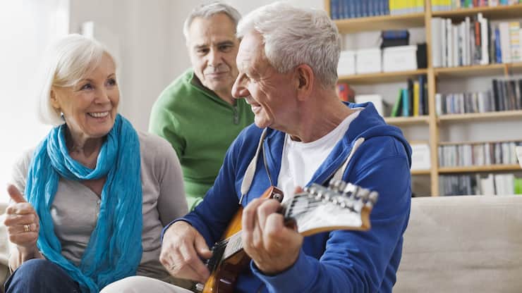 Germany, Leipzig, Senior man playing electric guitar, man and woman sitting besides model released property released PUBLICATIONxINxGERxSUIxAUTxHUNxONLY WESTF018885Germany Leipzig Senior Man Playing Electric Guitar Man and Woman Sitting besides Model released Property released PUBLICATIONxINxGERxSUIxAUTxHUNxONLY WESTF018885