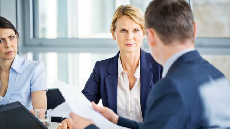 Senior businesswoman listening to her colleague during a staff meeting