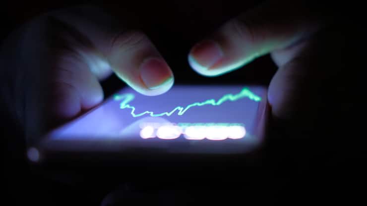 A businessman checking stock charts on a mobile device. Technology and work on the go.