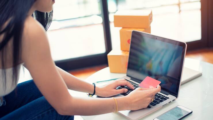 Young woman paying shopping online with a credit card at home
