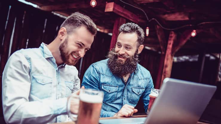 Freelancing Businessmen Drinking Beer And Working Together In A Bar