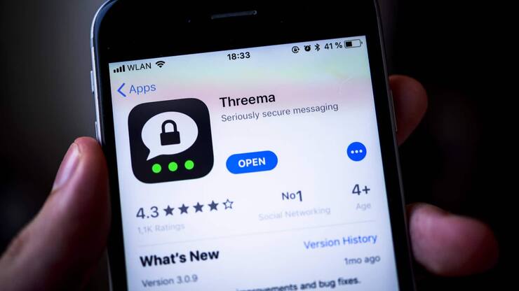 Hand hält iPhone mit Threema, sichere Instant Messenger App, im Apple App Store, App-Icon, Display, iPhone, iOS, Smartphone, Deutschland, Europa