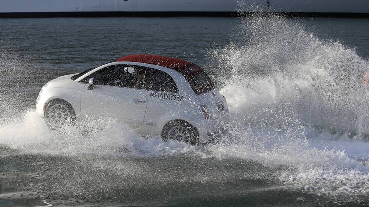 A Fiat 500 watercraft goes through the water as it escorts the MSC Divina cruise ship arrives at the Port of Miami, Tuesday, Nov. 19, 2013, in Miami. This is the ship's North American debut since departing Venice, Italy Nov. 2. The Divina will offer year-round Caribbean sailings from its home port of Miami. (AP Photo/Lynne Sladky)