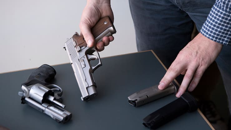 Eine Pistole SIG Sauer P226, Mitte, mit 15 und 20 Schuss-Magazin sowie eine Pistole Smith & Wesson 357 Magnum, links, werden an der Medienkonferenz ueber die Umsetzung der EU-Waffenrichtlinien praesentiert, am Freitag, 29. September 2017, in Bern. (KEYSTONE/Anthony Anex)