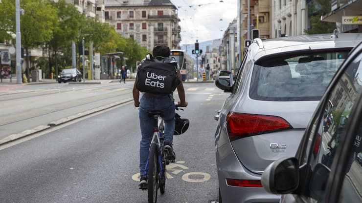 Un coursier partenaire de la societe Uber Eats roule en ville de Geneve avec un velo pour livrer des repas a domicile, ce lundi 19 aout 2019 a Geneve. (KEYSTONE/Salvatore Di Nolfi)