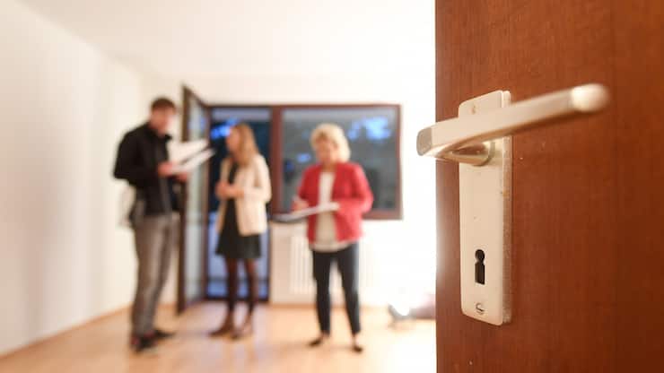 Eine Maklerin spricht mit Interessenten bei einer Wohungsbesichtigung während im Vordergrund eine Türklinke zu sehen ist. (zu dpa «Mieter und Vermieter immer seltener vor Gericht» vom 28.12.2018) Foto: Tobias Hase/dpa +++ dpa-Bildfunk +++ (KEYSTONE/DPA/Tobias Hase)