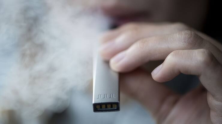 ARCHIV ? ZU DEN THEMEN AN DER HERBSTSESSION DER EIDGENOESSISCHEN RAETE VON HEUTE DIENSTAG, 17. SEPTEMBER 2019, STELLEN WIR IHNEN FOLGENDES BILDMATERIAL ZUR VERFUEGUNG - Eine Frau raucht ihre E-Zigarette Juul, aufgenommen am Dienstag, 4. Dezember 2018 in Zuerich. Juul wird heute in der Schweiz eingefuehrt. (KEYSTONE/Ennio Leanza)