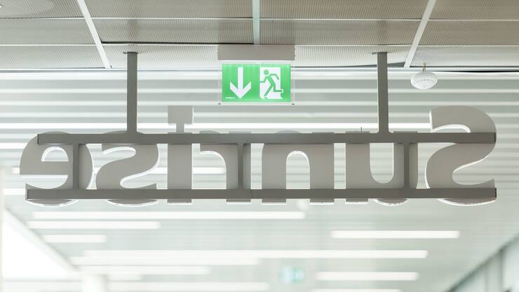 An emergency exit sign in a shop of the telecommunications provider Sunrise Communications at the shopping center En Felezin in Romanel-sur-Lausanne, Canton of Vaud, Switzerland, pictured on July 6, 2015. (KEYSTONE/Christian Beutler)