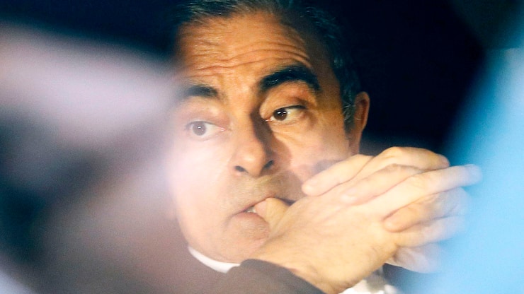 In this March 6, 2019, photo, former Nissan chairman Carlos Ghosn rides in a car from a building in Tokyo. Ghosn, the star auto executive credited with rescuing both Renault and Nissan, left a drab Tokyo detention center Wednesday after more than three months in custody, his identity obscured by a surgical mask, hat, and construction worker's outfit.(Takuya Inaba/Kyodo News via AP, File)