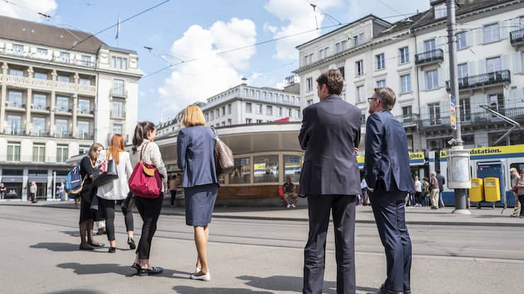 Passanten warten an der Tramstation am Zuercher Paradeplatz, am Mittwoch, 9. Mai 2018, in Zuerich. (KEYSTONE/Patrick Huerlimann)