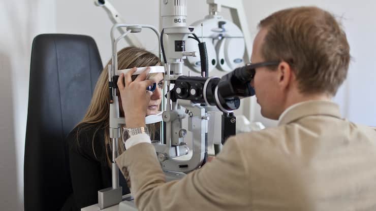 An oculist examines the retina of a patient with the aid of a slit lamp. Pictured on November 12, 2011 in Zurich, Switzerland. (KEYSTONE/Gaetan Bally)Ein Augenarzt untersucht mit der sogenannten Spaltlampe die Netzhaut der Augen einer Patientin, aufgenommen am 12. November 2011 in Zuerich. (KEYSTONE/Gaetan Bally)
