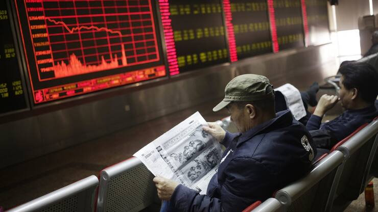 epa05087380 Chinese investors read newspapers in front of a screen showing stock movements at a stock brokerage house in Beijing, China, 04 January 2016. Shares plunged across Asia and trading was halted on the Chinese markets 04 January on a miserable start to 2016 for investors in the region. Trading on China's main bourses, the Shanghai and Shenzhen stock exchanges, halted for the day as a benchmark index fell over 7 per cent off the back of weak Chinese manufacturing data.  EPA/HOW HWEE YOUNG