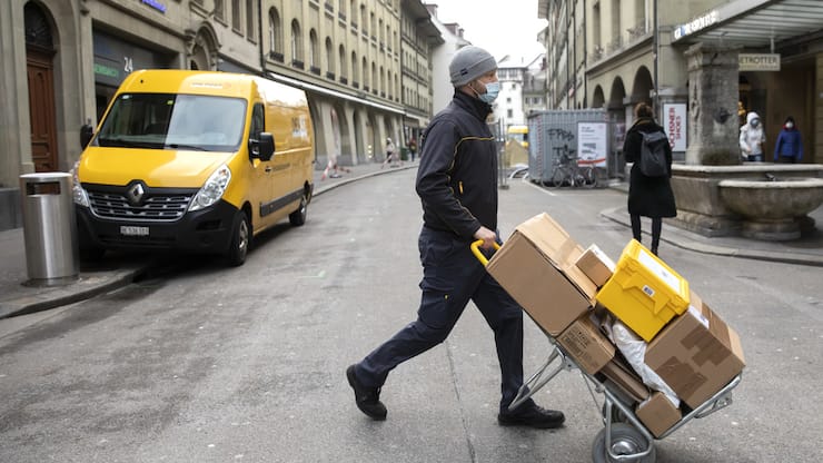 Ein Paketbote der Post liefert Pakete aus, am Donnerstag, 11. Februar 2021, in Bern. (KEYSTONE/Peter Klaunzer)