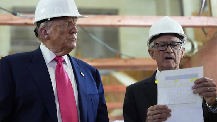 Federal Reserve Chairman Jerome Powell looks over a document of cost figures as President Donald Trump watches during a visit to the Federal Reserve, Thursday, July 24, 2025, in Washington. (AP Photo/Julia Demaree Nikhinson)