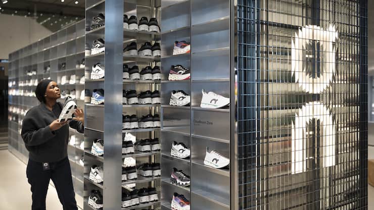 Eine Mitarbeiterin von On raeumt Sportschuhe der Sportmarke On im Laden On am Hauptstandort der Sportmarke ein, fotografiert am Mittwoch, 22. Januar 2025, am Hauptsitz von On in Zuerich. (KEYSTONE/Gaetan Bally)