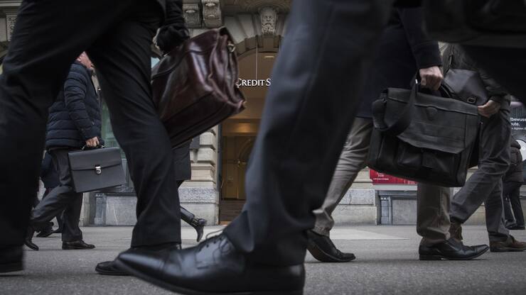People walk in the front of the Credit Suisse bank at the tram stop Paradeplatz in the square's centre in Zurich, Switzerland, Wednesday, Feburary 14, 2018. (KEYSTONE/Ennio Leanza).