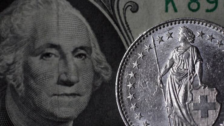 Die Helvetia auf der 2 Franken Muenze schaut George Washington auf dem US Dollar ins Gesicht am Freitag, 14. Maerz 2008 in Zuerich. Der Dollar ist heute Freitag erstmals weniger als einen Franken wert gewesen. Am Nachmittag kostete ein Dollar voruebergehend 0.9986 Franken. Auch gegenueber anderen Waehrungen kam er wegen schlechten US-Wirtschaftsnachrichten stark unter Druck. (KEYSTONE/Alessandro Della Bella)