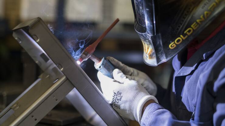 adarasa Ravinthiran schweisst am Chassis der Olympia Express ÇCreminaÈ Kaffeemaschine, in der Firma Schaetti Ð Olympia Express, Hersteller von hochwertigen Kaffeemaschinen und Kaffeemuehlen fuer den Haushaltsgebrauch