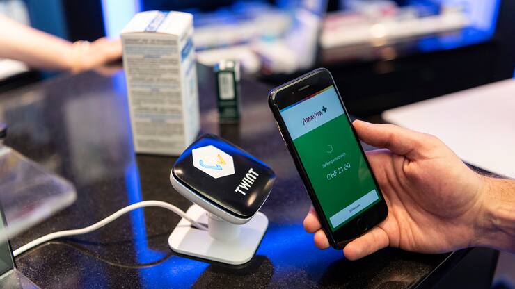 [Staged Picture] A person uses the Twint cashless payment system via app on a smartphone at a Twint beacon terminal in an Amavita pharmacy in Berne, Switzerland, on May 2, 2018. (KEYSTONE/Christian Beutler)