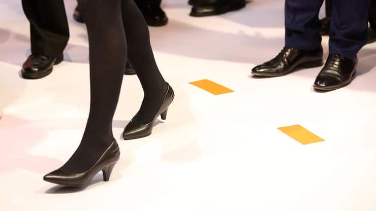 ARCHIV - 16.03.2015, Niedersachsen, Hannover: Eine Geschäftsfrau mit Pumps und Kostüm steht zwischen Geschäftsleuten mit Anzug auf einem Messestand auf der CeBIT. Frauen sind in Spitzenämtern der Thüringer Landesverwaltung noch immer unterrepräsentiert. (zu "Frauenanteil bei Spitzenjobs in Behörden bei 25 Prozent" vom 14.01.2019) Foto: Christian Charisius/dpa +++ dpa-Bildfunk +++ (KEYSTONE/DPA/Christian Charisius)