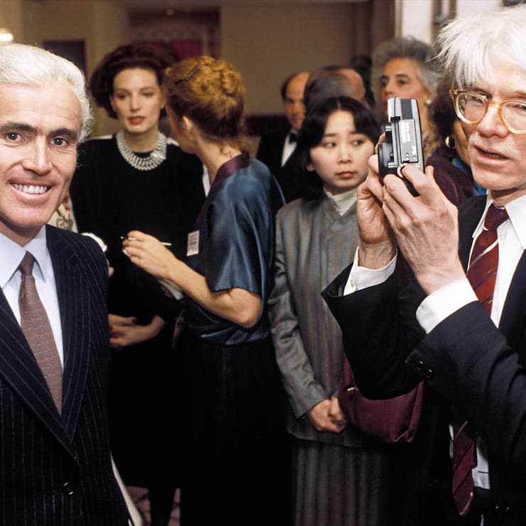 Andy Warhol (rechts) ist kurz davor, Yves Piaget an einem Event zu fotografieren (Washington DC, 1984). 