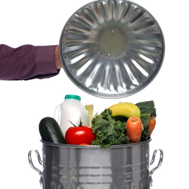 Dust bin full of fresh food, studio shot.