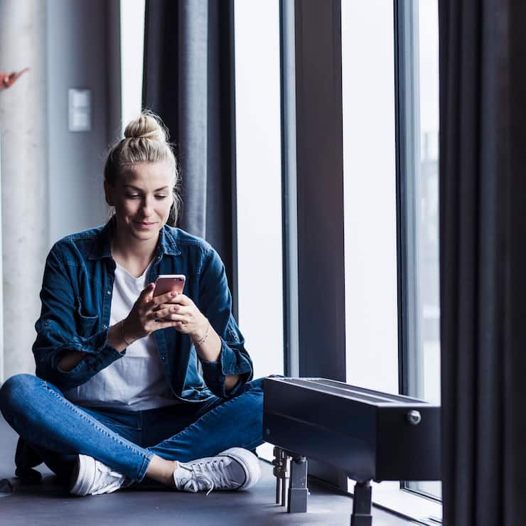 Woman sitting in an office using a smartphone by the window model released, Symbolfoto property released, UUF34207