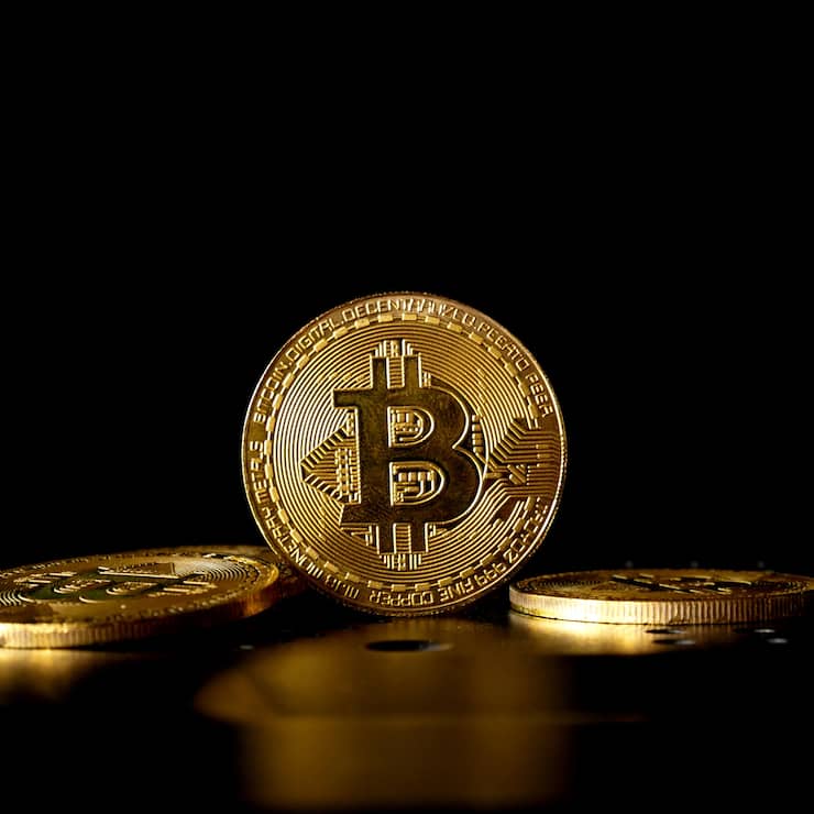 Close up of gold bitcoin on black background with selective focus