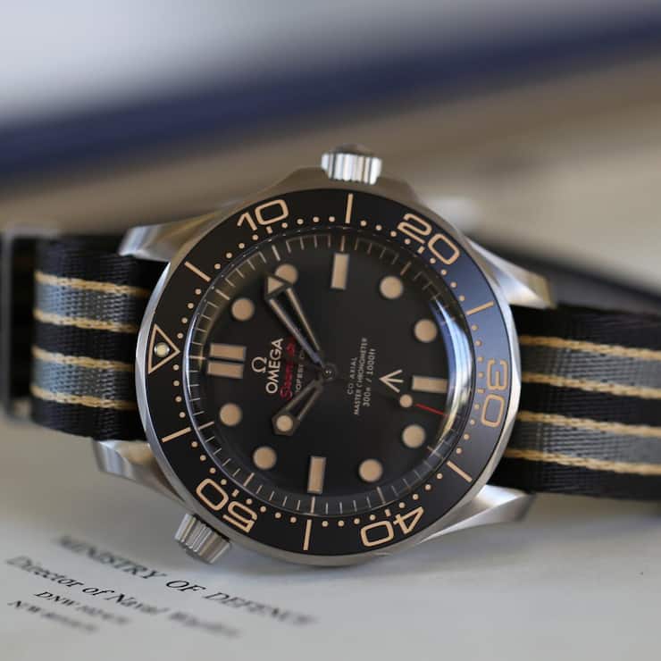 Die 2019 vorgestellte Seamaster Diver 300M «No Time To Die» aus Titan brachte eine Rückkehr der Keramik- zur Aluminium-Einlage für den einseitig rastenden Drehring, ein stark gewölbtes Saphirglas und militärische Ordonnanzzeichen. Sie wurde umgehend zum Bestseller – und zur Blaupause für aktuell vier weitere Modelle ähnlicher Bauart.