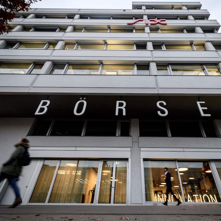 People walk in front of the headquarters of the Swiss Stock Exchange (Boerse) operated by the SIX group in Zurich on November 29, 2018. - According to a EU Commission document, for now, not enough progress on the Swiss-EU framework agreement has been made to renew the 'financial equivalency' status of the Swiss stock exchange in Europe, media reported on November 28, 2018. (Photo by Fabrice COFFRINI / AFP)