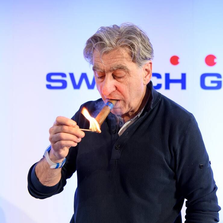 Nick Hayek, CEO Swatch Group, President of the Swatch Group Executive Management Board lights his cigar during a press conference of the year 2017 final results of Swiss watch company Swatch Group, in Biel, Switzerland, this Wednesday, March 14, 2018. (KEYSTONE/Anthony Anex)