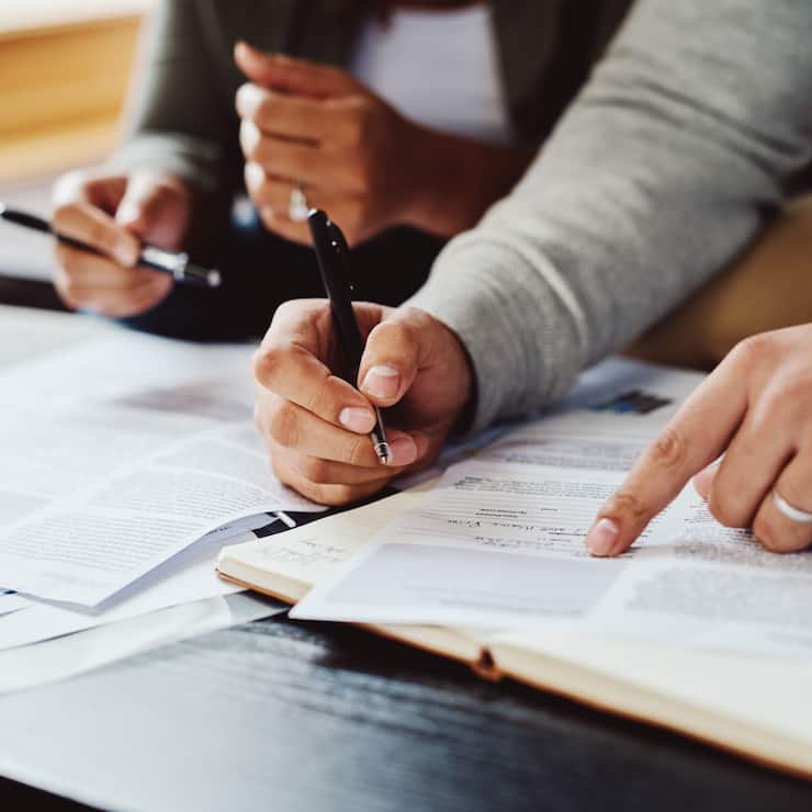 Closeup shot of an unrecognizable couple going through paperwork together at home