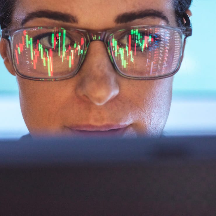 Stockbroker analyzing financial stock market with reflection on eyeglasses