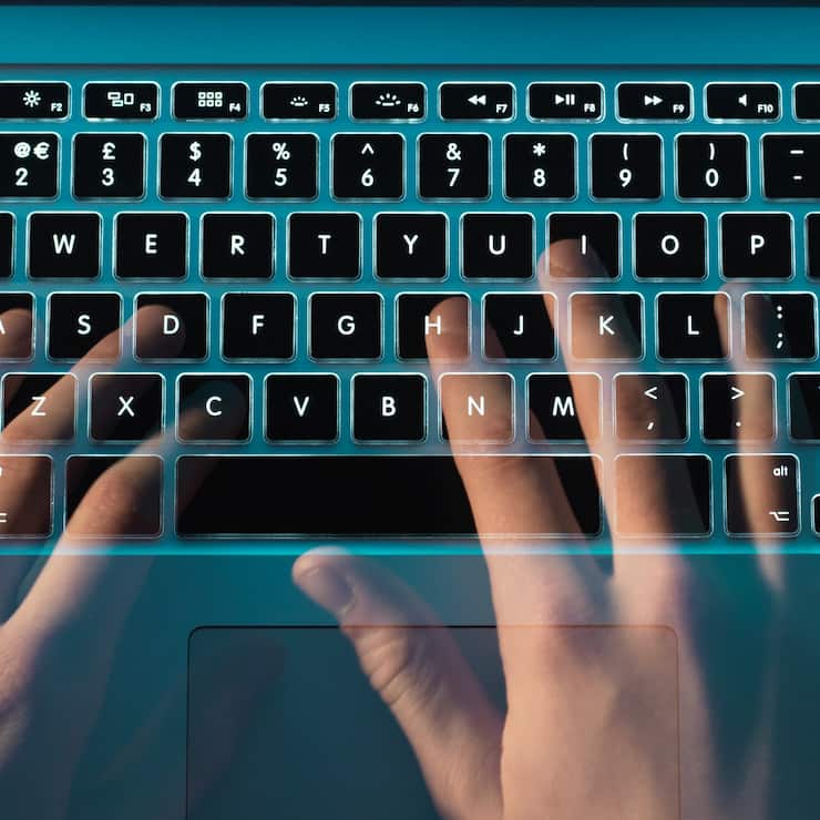 Hands of hacker coding computer virus on laptop