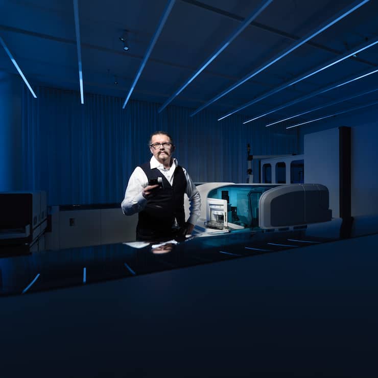 PD Dr. med. Michael Hombach, Director, Senior Global Clinical Leader Infectious Diseases poses with a Elecsys Anti-SARS-CoV-2 test next to a Cobas Elecsys 801 machine at Roche Diagnostics in Rotkreuz, Canton of Zug, Switzerland on May 15, 2020.  Photo: Â© 2020 Michael Buholzer