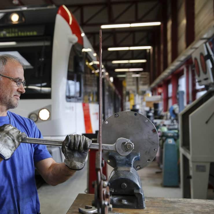 An employee services components at the Stadler Rail AG service facility in Wil, Switzerland, on Tuesday, Oct. 8, 2019