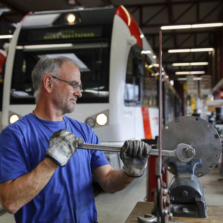 An employee services components at the Stadler Rail AG service facility in Wil, Switzerland, on Tuesday, Oct. 8, 2019. Stadler, a Swiss manufacturer of trains and trams, is on track to double its annual turnover to 4 billion francs ($4 billion) by next year, compared with 2018, without having to resort to big acquisitions thanks to a full order book, billionaire chairman and majority shareholder Peter Spuhler said in an interview with Finanz und Wirtschaft. Photographer: Stefan Wermuth/Bloomberg