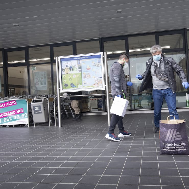 Die Freiwilligenhelfer Adem Salimi, links, und Angelo Vellani, rechts, machen Einkaeufe fuer eine betagte Person, am Montag, 23. Maerz 2020, in Biasca. Aufgrund des Coronavirus verzichten viele aeltere Personen darauf, selber Einkaeufe zu taetigen. (KEYSTONE/Ti-Press/Pablo Gianinazzi)