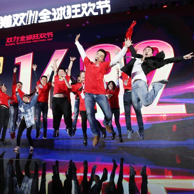 SHANGHAI, CHINA - NOVEMBER 12:  Staff members and journalists pose with the screen showing Alibaba's GMV of the Single's Day Global Shopping Festival at Shanghai Expo Centre on November 12, 2017 in Shanghai, China. Alibaba Group generated RMB 168.2 billion (or USD 25.3 billion) of gross merchandise volume (GMV) in the Single's Day Global Shopping Festival on Nov 11.  (Photo by VCG/VCG via Getty Images)