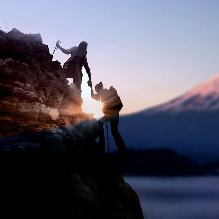 Young Asian couple  hikers climbing up on the peak of mountain near mountain Fuji .Climbing ,Helps and Team work concept .