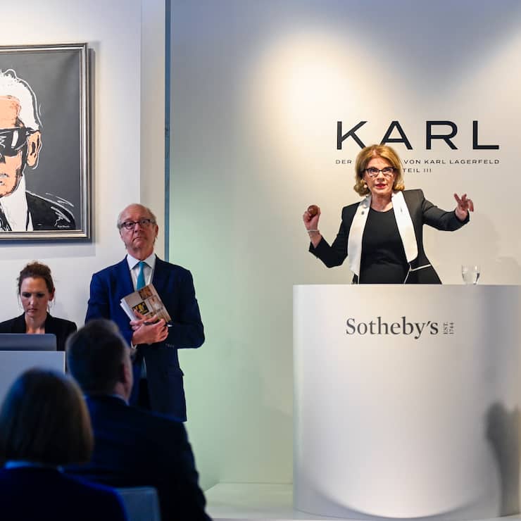 Auktionatorin gestikuliert während einer Lagerfeld-Auktion