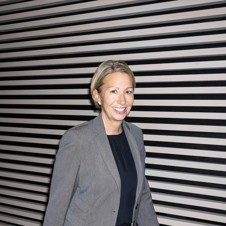 Portrait von Andrea Ryth, vor schwarz-weiss gestreifter Wand.