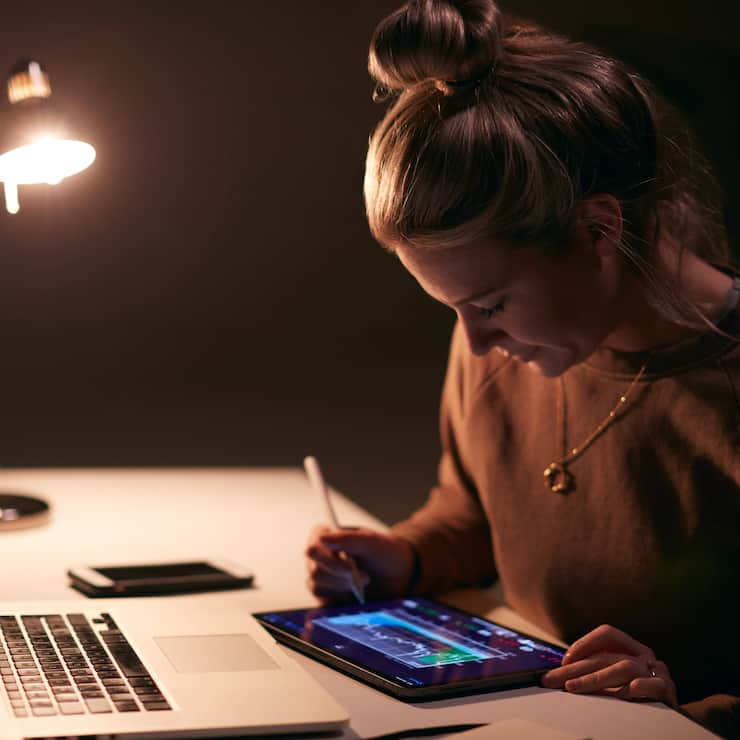 Eine junge Börsenhändlerin verfolgt Aktienkurse am PC.