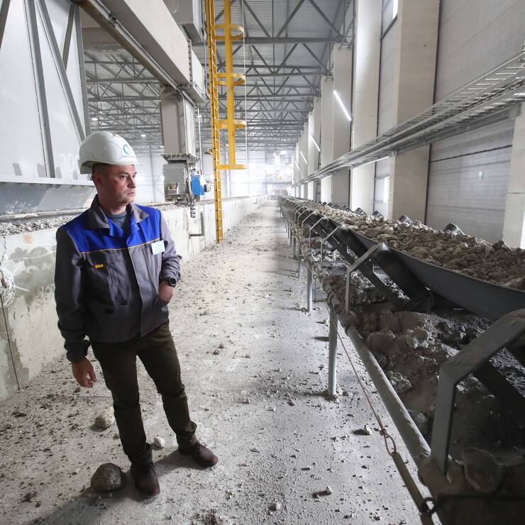 Ein Arbeiter sieht sich eine Rohmaterial-Transportlinie in einem Zementwerk in der Stadt Mikhailovka, Region Wolgograd, Russland, an