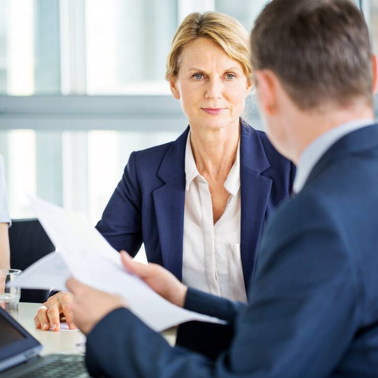 Senior businesswoman listening to her colleague during a staff meeting