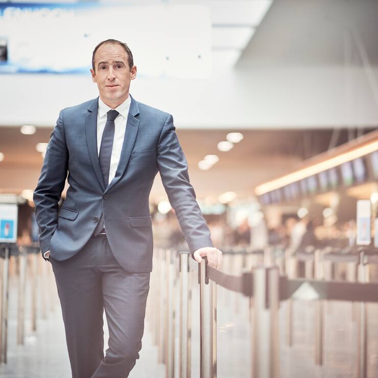 Flughafen-Chef Stephan Widrig steht in einer Check-In-Reihe am Flughafen.
