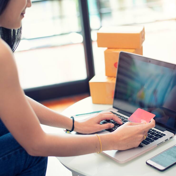 Young woman paying shopping online with a credit card at home